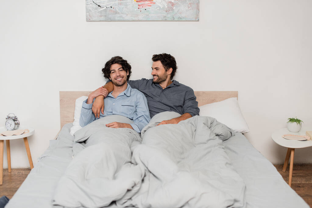 alegre gay casal sorrindo enquanto refrigeração no cama - Foto, Imagem