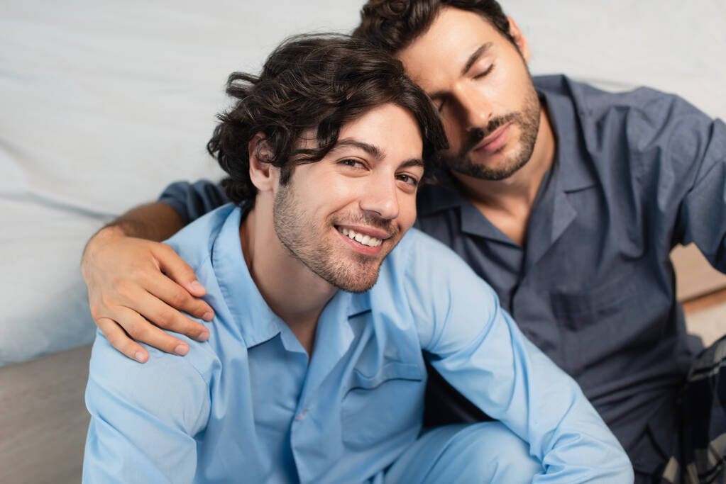 zadowolony młody gej para przytulanie w sypialnia - Zdjęcie, obraz
