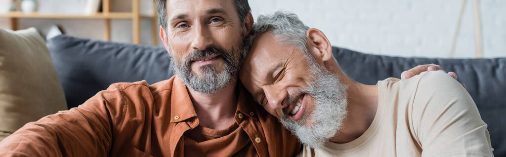 Homosexual man embracing smiling partner at home, banner  - Photo, Image