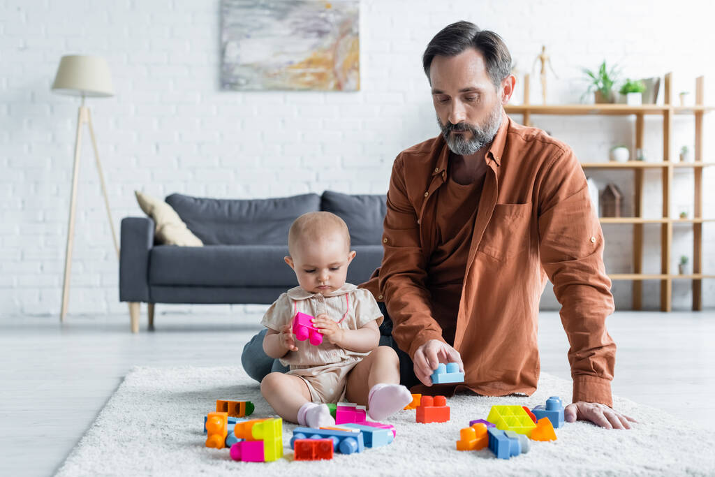 Pai jogando blocos de construção coloridos com a filha da criança  - Foto, Imagem