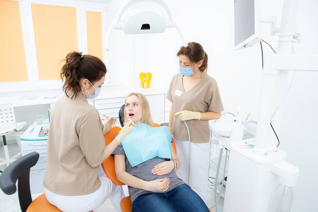 terhes nő a fogorvosi rendelőben, szűrés és fogászati kezelés terhes nők számára. - Fotó, kép