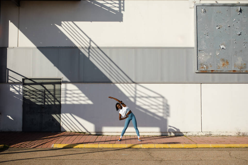 Фітнес розтягування розігрівати вправи перед тренуванням. Підходить для тренування жінок на вулиці в місті
. - Фото, зображення