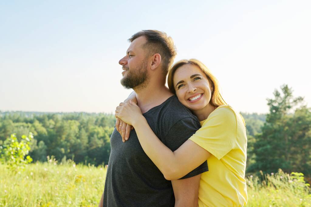 Porträt eines glücklichen Paares mittleren Alters an einem sonnigen Sommertag - Foto, Bild