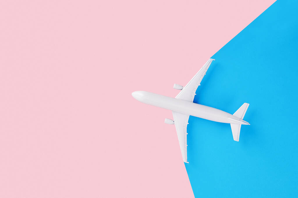 Un avion jouet isolé sur fond rose et bleu - Photo, image