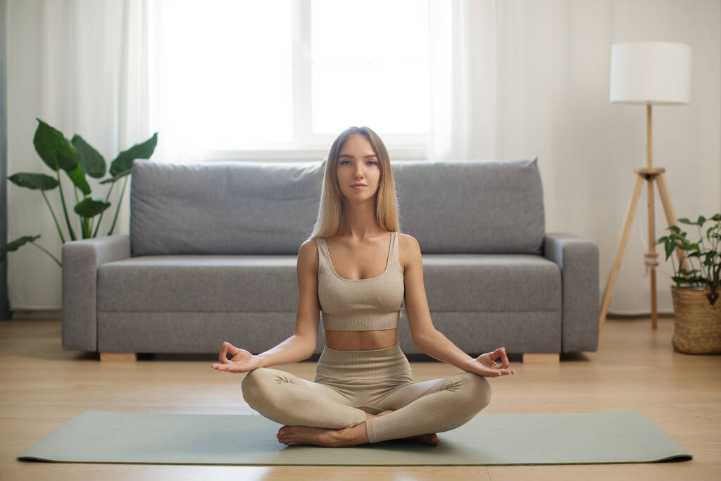 Femme en méditation sur tapis de yoga à la maison - Photo, image