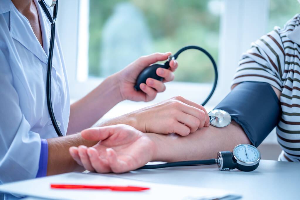 El médico mide la presión del paciente durante un examen médico y una consulta en el hospital. - Foto, imagen