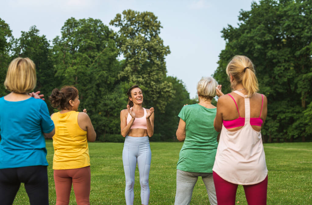 Grupo multiétnico de mujeres mayores entrenando en el parque con instructor de fitness - Personas mayores activas haciendo deporte en la naturaleza - Foto, Imagen