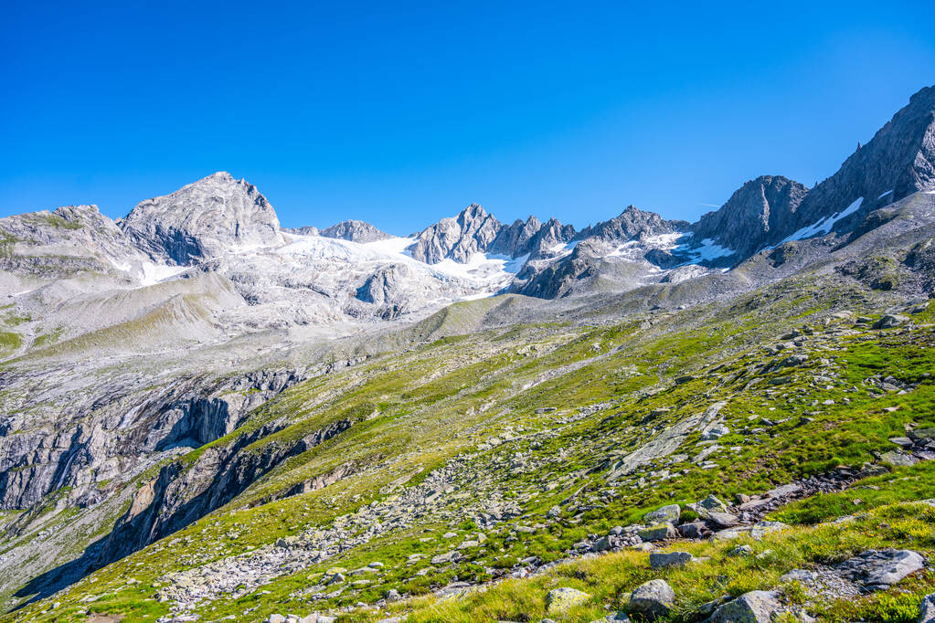 Szczyty alpejskie z topniejącym lodowcem w słoneczny letni dzień - Zdjęcie, obraz