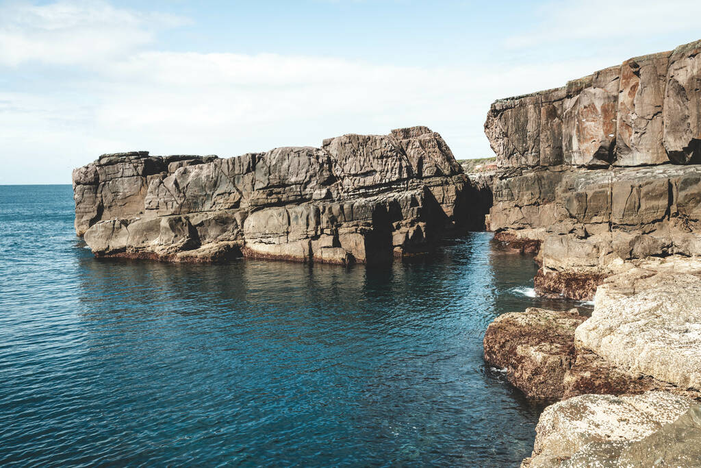 Ένα όμορφο τοπίο με τη γαλάζια θάλασσα ανάμεσα σε βραχώδη βράχια - Φωτογραφία, εικόνα