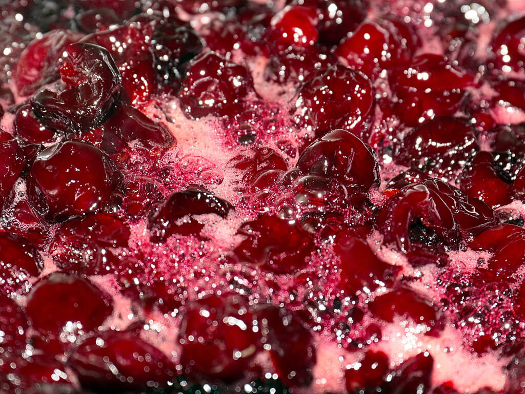 bolle d'aria e schiuma dolce sulla superficie della marmellata di ciliegie durante la cottura - Foto, immagini
