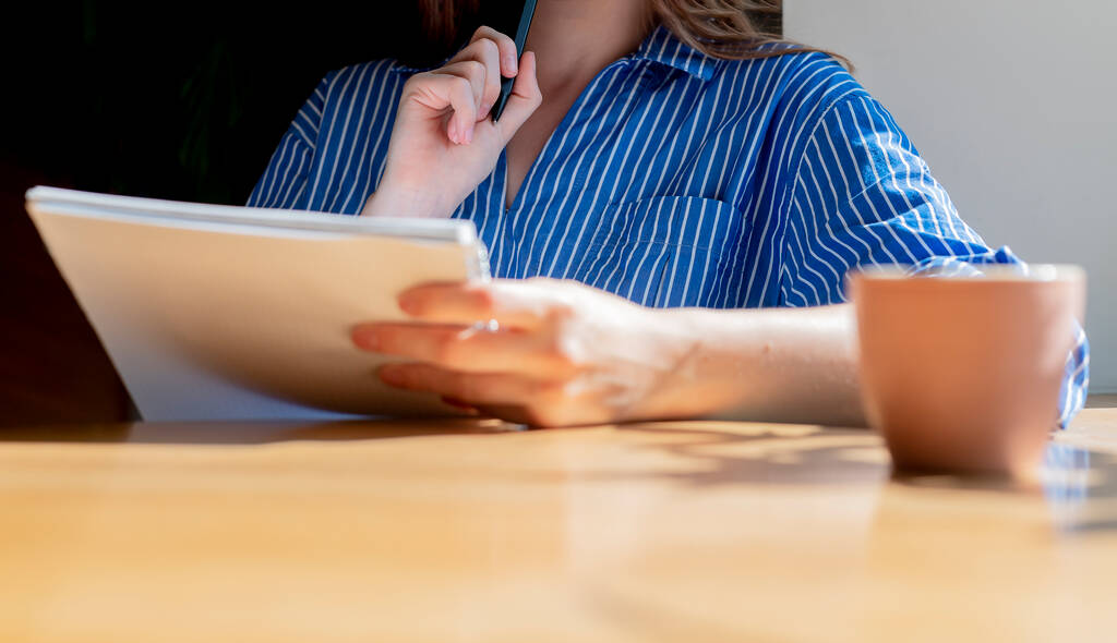 Οι γυναίκες κλείνουν τα χέρια κρατώντας σημειωματάριο, διαβάζοντας αναλυτικό πρόγραμμα στην καφετέρια με φλιτζάνι καφέ στο ξύλινο τραπέζι. Αντιγραφή διαθέσιμου χώρου για κείμενο - Φωτογραφία, εικόνα