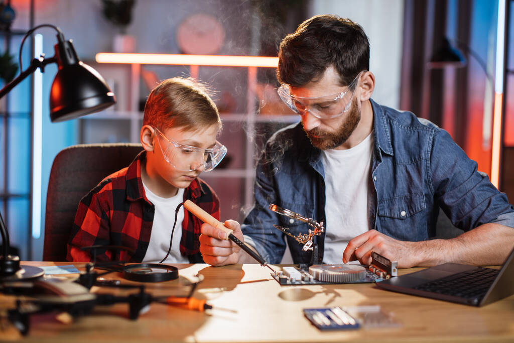 Bearded man and little boy soldering display card - Photo, Image