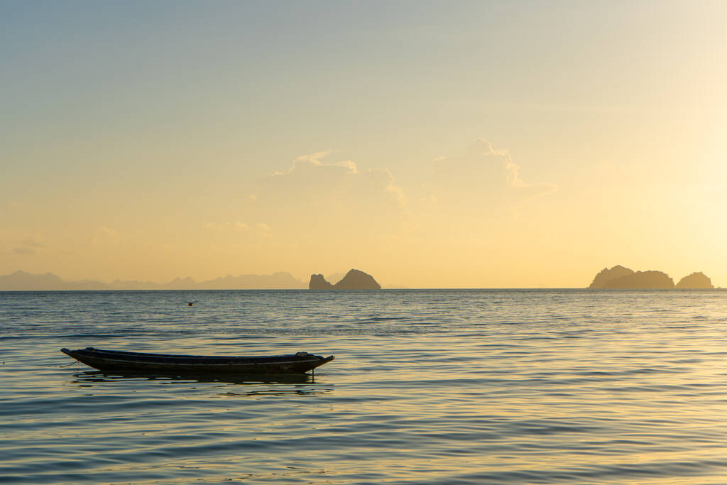 Красивый закат на побережье тропического острова в Таиланде, силуэт лодки в океане. - Фото, изображение