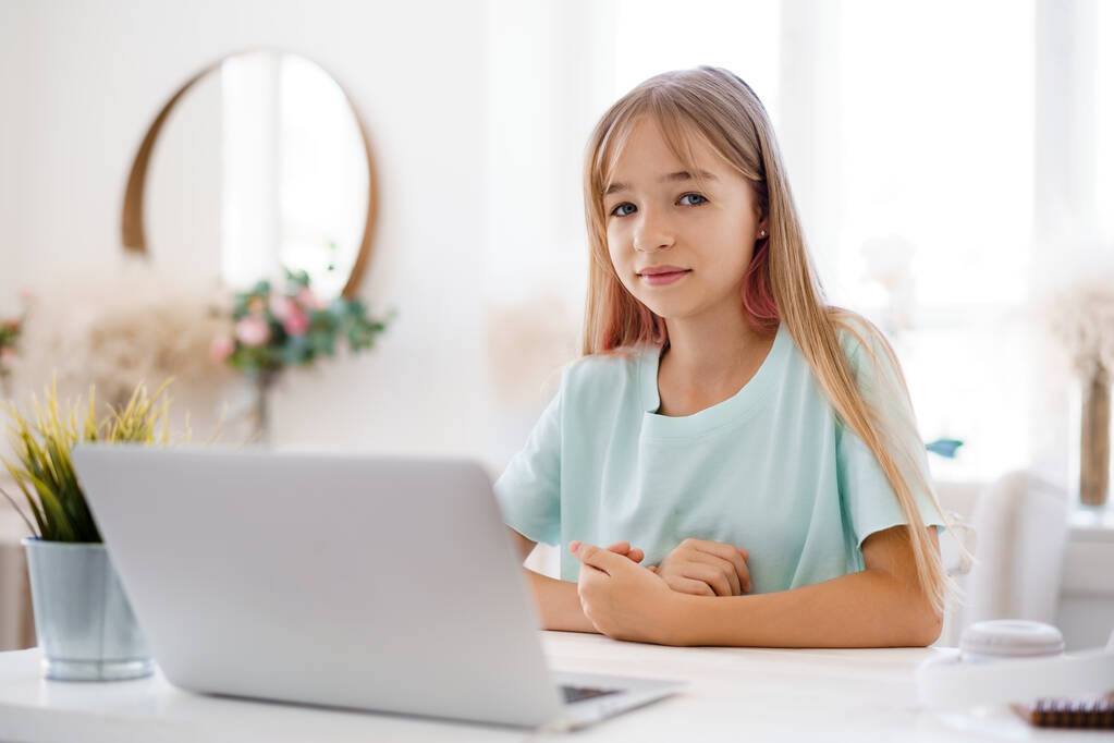 Glückliche kleine Schülerin mit Laptop zu Hause - Foto, Bild
