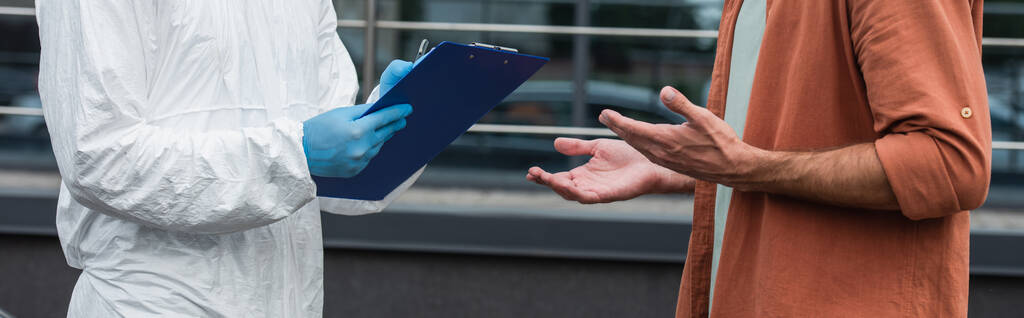 Обрезанный вид человека, стоящего рядом с медицинским работником, пишущего на планшете на открытом воздухе, баннер  - Фото, изображение