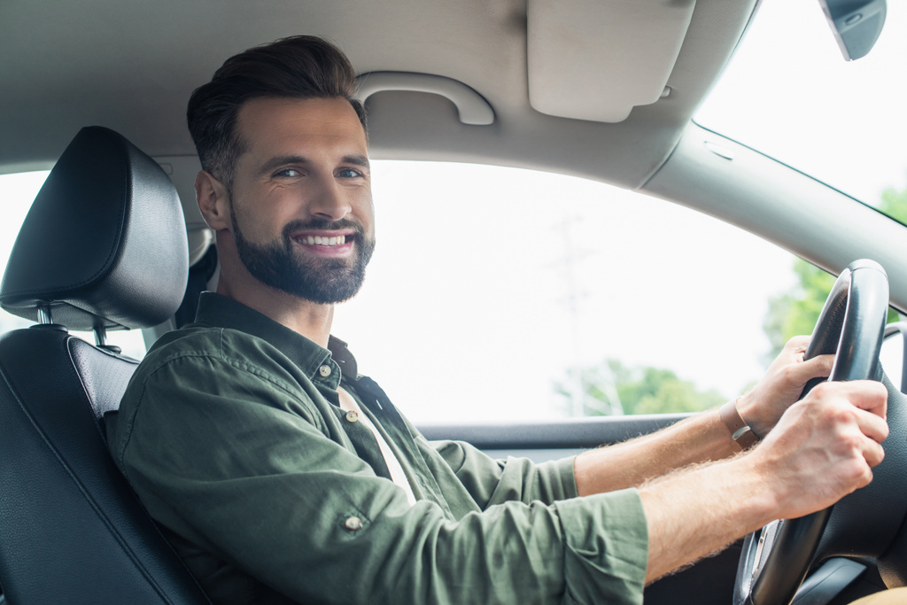 Бородатий водій посміхається на камеру в авто
  - Фото, зображення