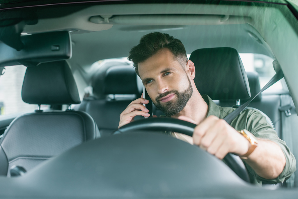 Γενειοφόρος οδηγός μιλάει στο smartphone στο auto  - Φωτογραφία, εικόνα