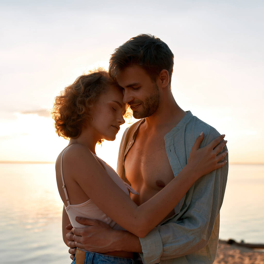 Piękna młoda kaukaska para przytula się na plaży - Zdjęcie, obraz