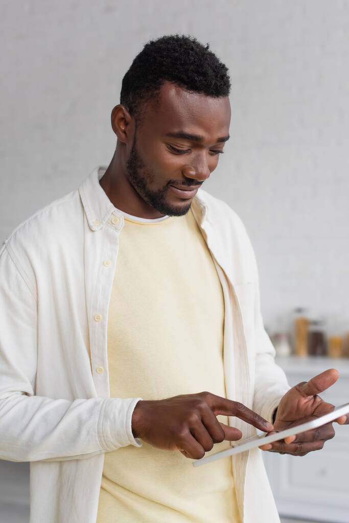 mosolygós afro-amerikai férfi használ digitális tabletta otthon - Fotó, kép