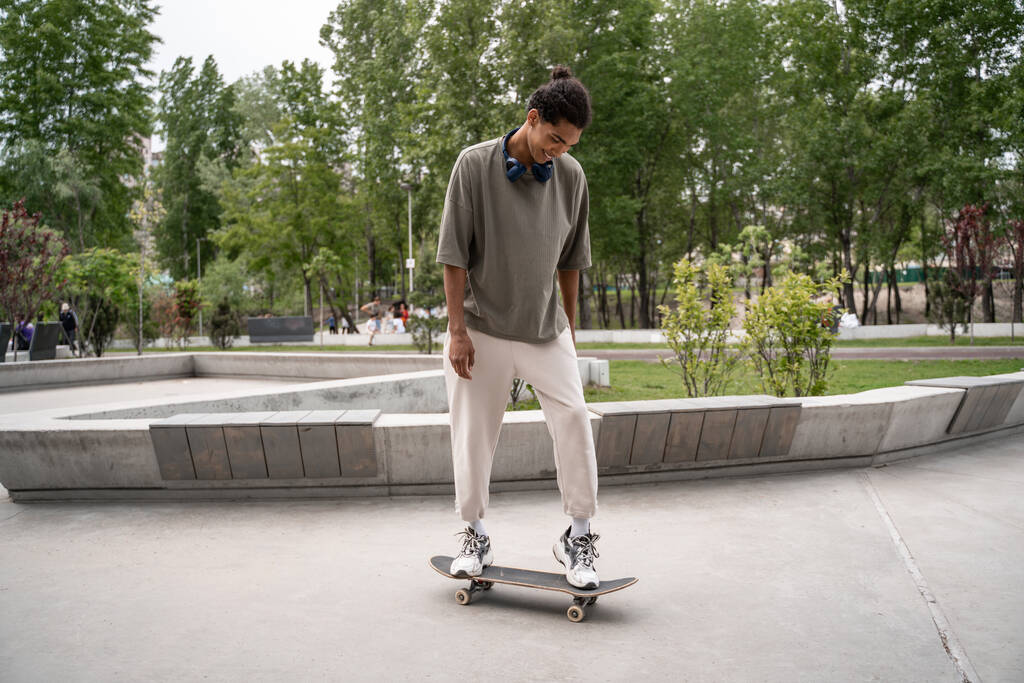 jeune homme afro-américain à cheval skateboard dans le parc - Photo, image