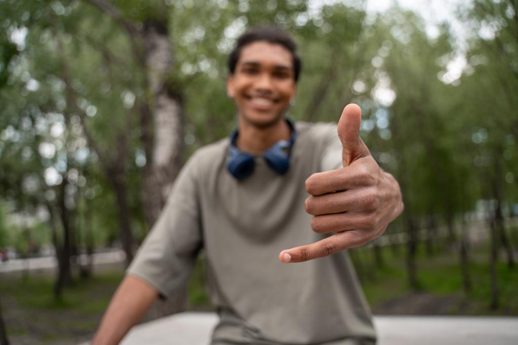zamazany Afrykański Amerykanin uśmiecha się i pokazuje luźny gest na zewnątrz - Zdjęcie, obraz