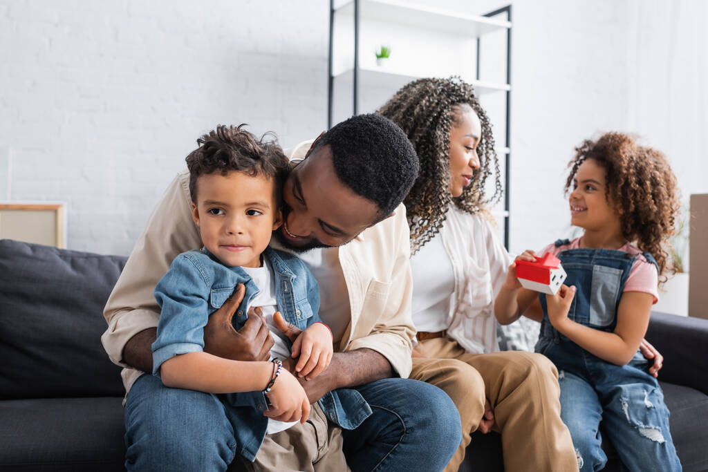 幸せなアフリカ系アメリカ人の家族がソファに座って - 写真・画像