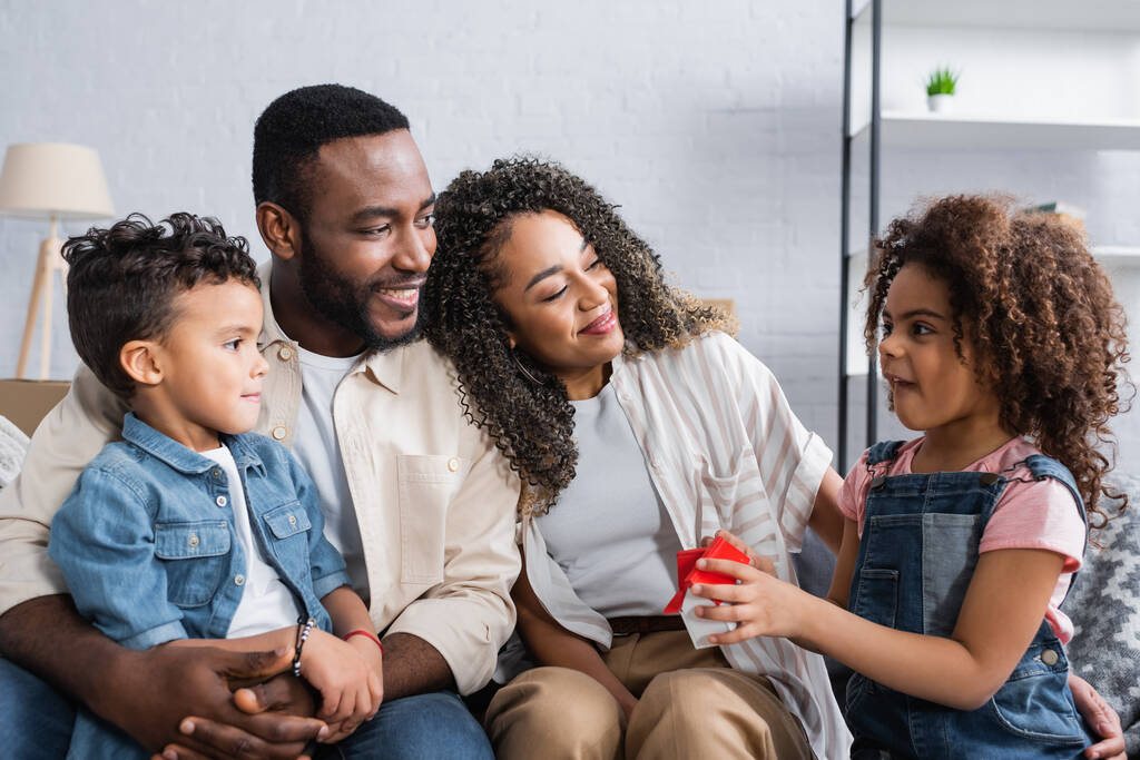 Afrikai amerikai gyerek gazdaság ház modell közel boldog család új lakás  - Fotó, kép