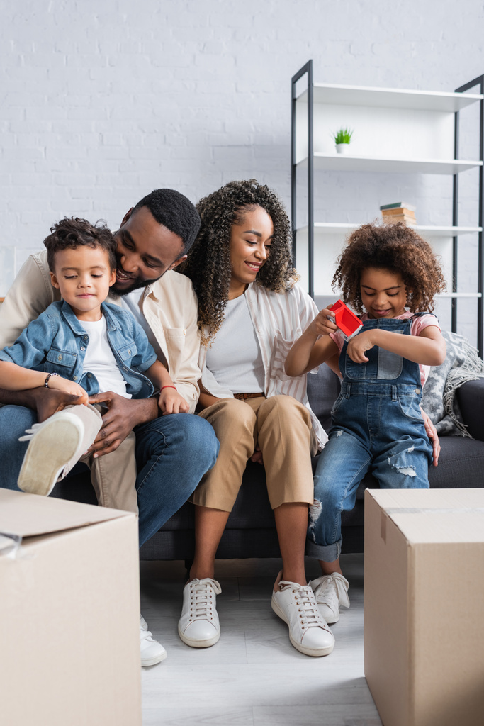 familia afroamericana sentada en sofá cerca de cajas de cartón - Foto, imagen