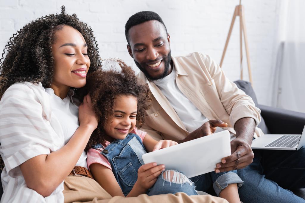 afroamericana chica usando laptop cerca feliz madre y padre con laptop - Foto, imagen