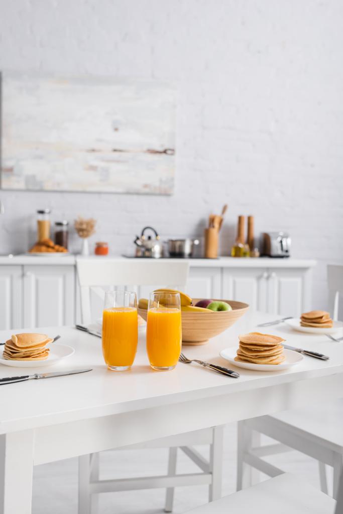 新鮮な果物、おいしいパンケーキとオレンジジューステーブルの上で朝食を提供 - 写真・画像
