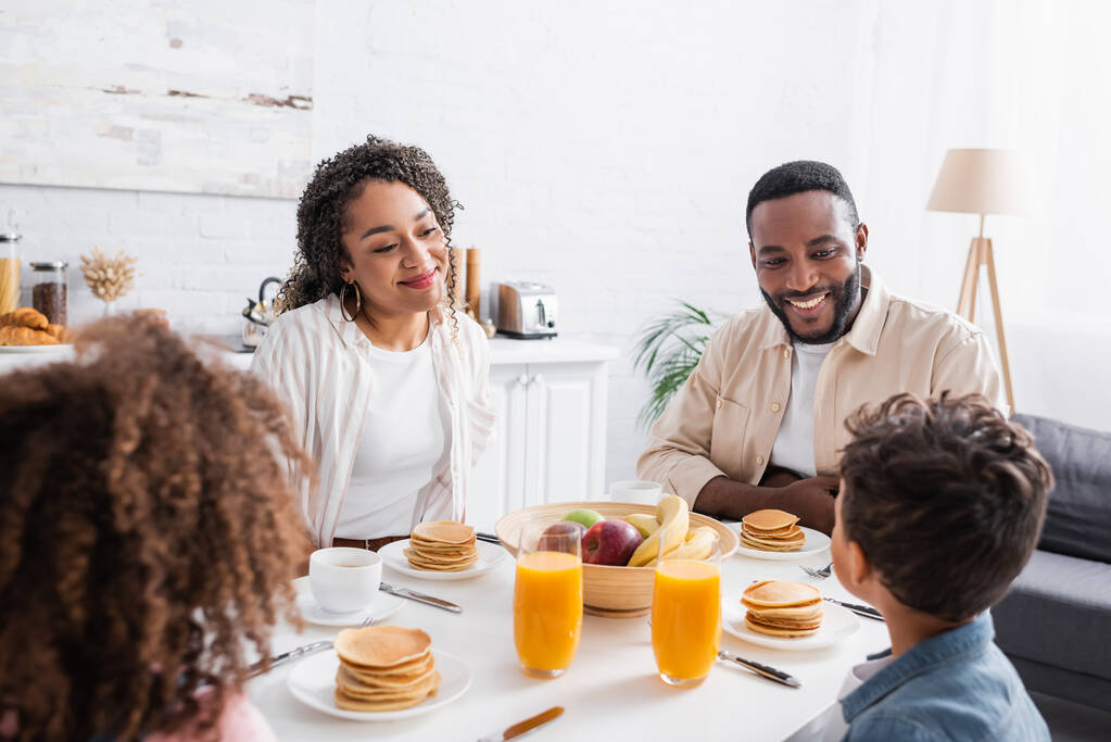 Χαρούμενη αφροαμερικάνικη οικογένεια που τρώει πρωινό στην κουζίνα - Φωτογραφία, εικόνα