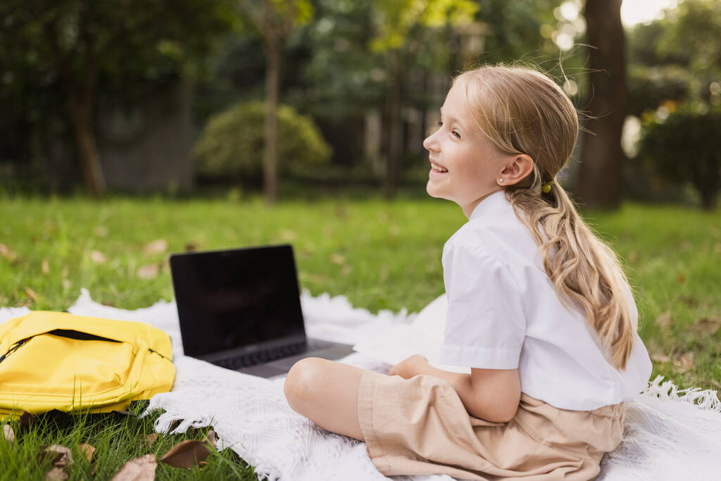 heureux enfant caucasien a leçon en ligne sur ordinateur portable pendant coronavirus covid-19 pandémie et verrouillage - Photo, image