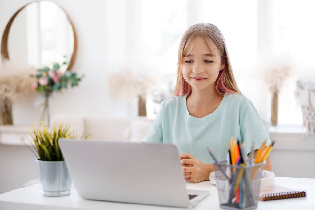 gelukkig klein meisje leerling met behulp van laptop thuis - Foto, afbeelding