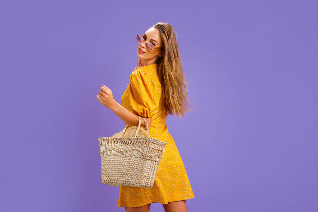 Модна жінка в гарній жовтій сукні і солом'яній сумці. Мода весна літо фото
 - Фото, зображення