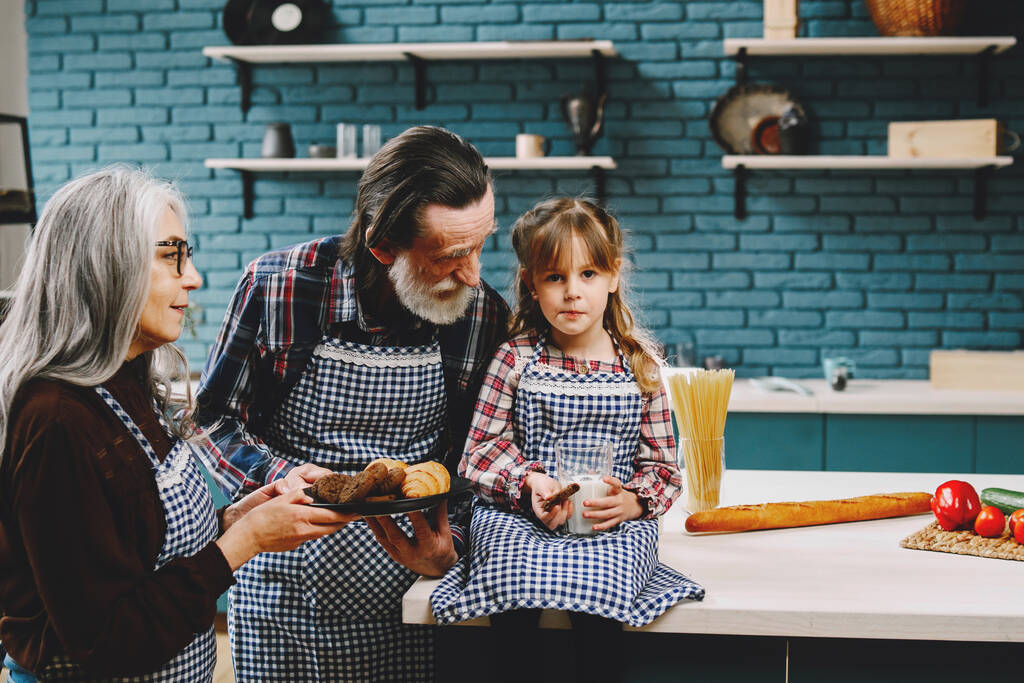 Menina comendo na cozinha com avós - Foto, Imagem