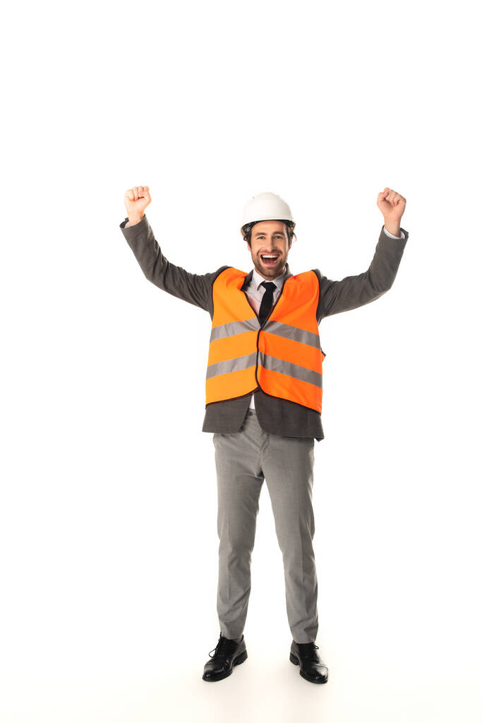 Izgalmas biztonsági mellényes mérnök, aki igen gesztust mutat fehér alapon  - Fotó, kép