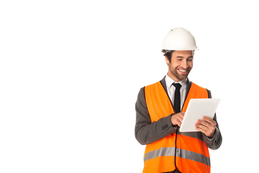 Usmívající se inženýr v záchranné vestě pomocí digitálního tabletu izolovaného na bílém  - Fotografie, Obrázek