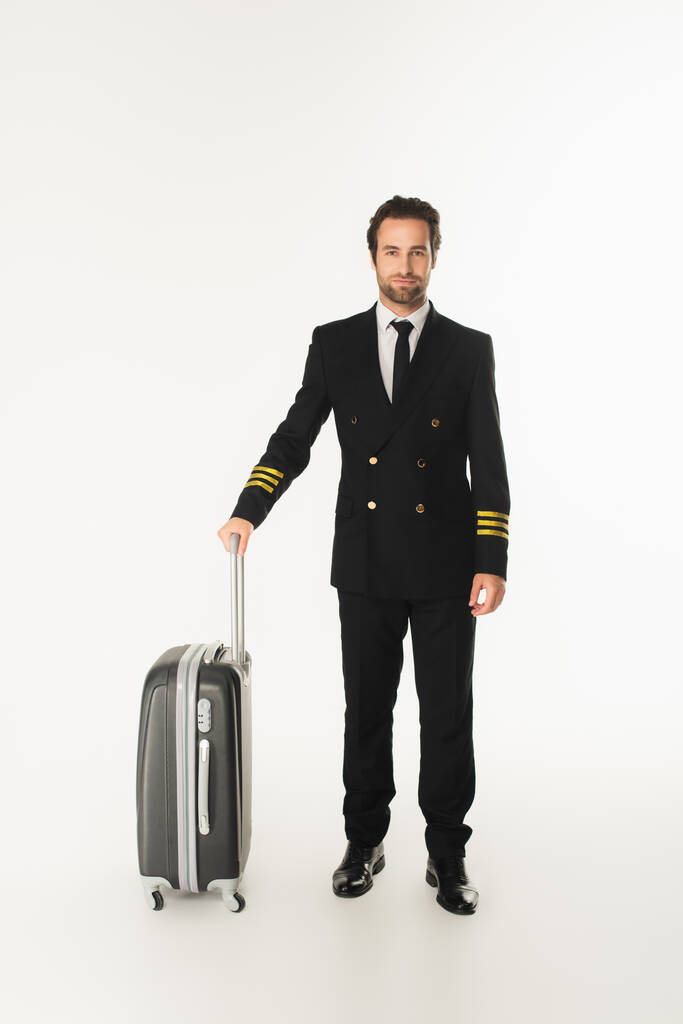 Młody pilot z walizką stojącą na białym tle  - Zdjęcie, obraz