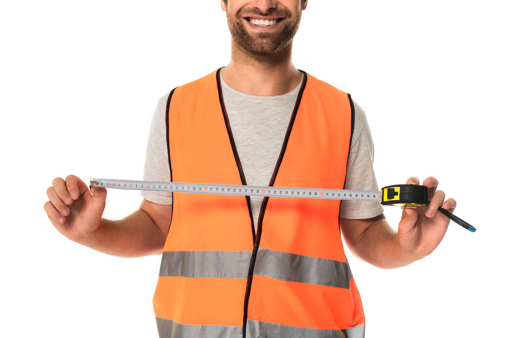 Gebonden weergave van glimlachende bouwer holding tape maatregel geïsoleerd op wit  - Foto, afbeelding