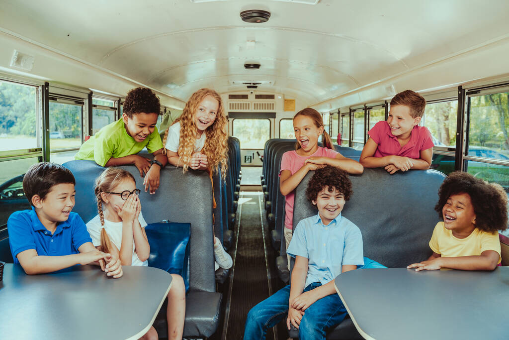 黄色のスクールバスに乗って小学生のグループ-小学校の子供たちが楽しい1を持っている - 写真・画像