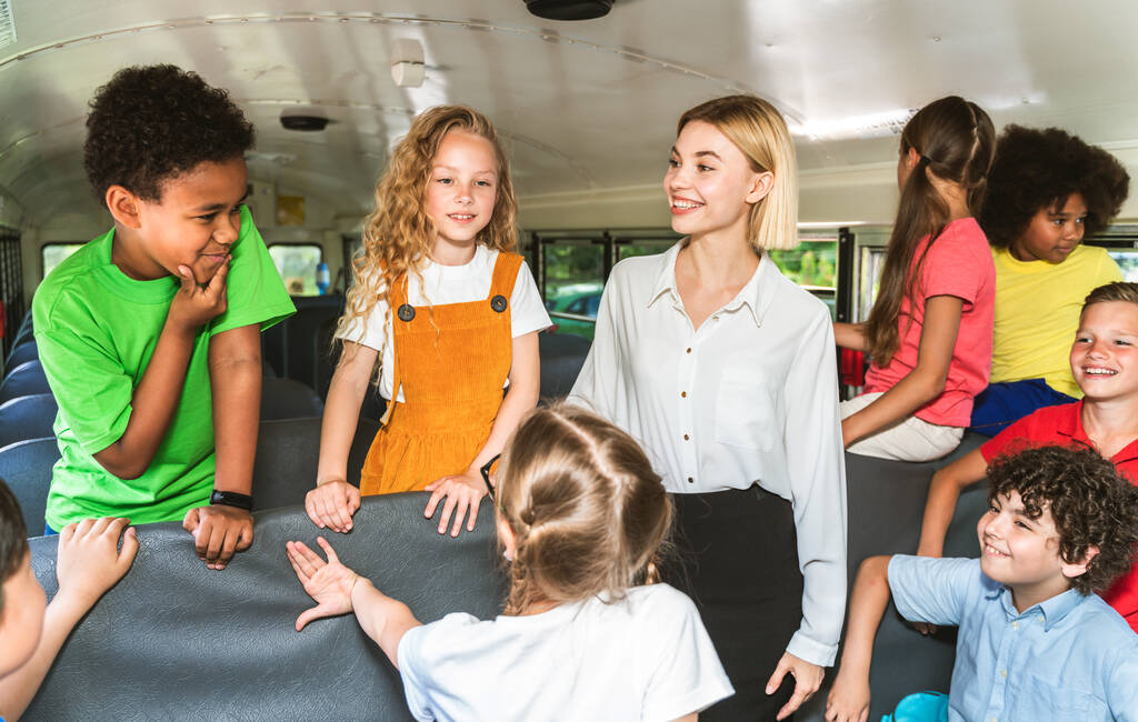 Grupo de jovens estudantes que frequentam a escola primária em um ônibus escolar amarelo - crianças da escola primária se divertindo - Foto, Imagem