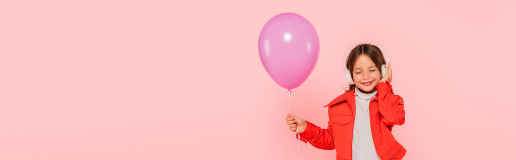 Tyttö juhlava ilmapallo kuuntelee musiikkia suljetuin silmin eristetty vaaleanpunainen, banneri - Valokuva, kuva