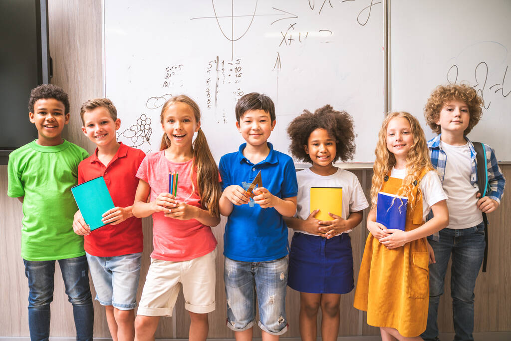 Groupe multiracial d'enfants à l'école primaire - Écoliers ludiques profitant du temps de l'école et de la leçon avec l'enseignant et ses camarades de classe - Photo, image