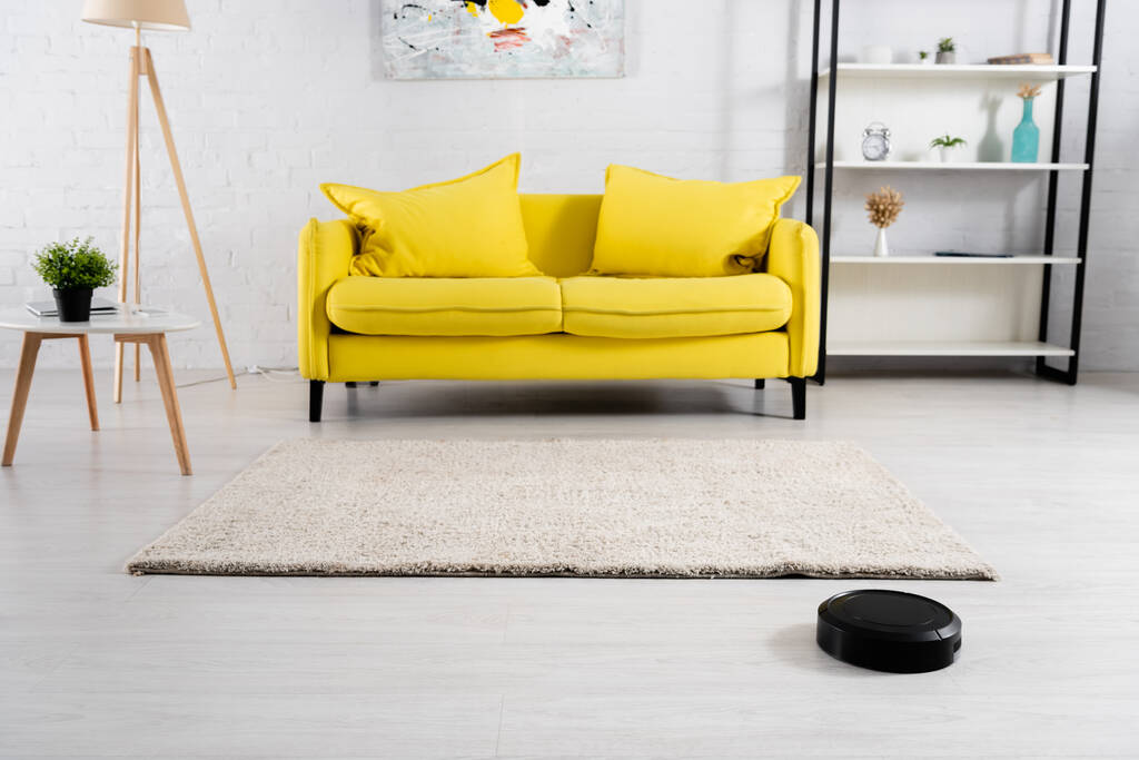 A nappali belseje robotporszívóval a padlón  - Fotó, kép