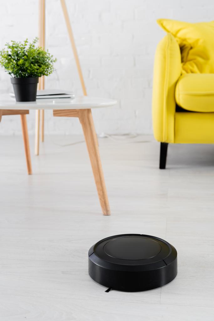 Aspiradora robótica en el suelo en la sala de estar borrosa  - Foto, imagen