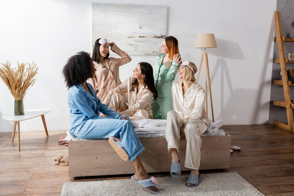 group of happy interracial friends in pajamas during slumber party   - Photo, Image