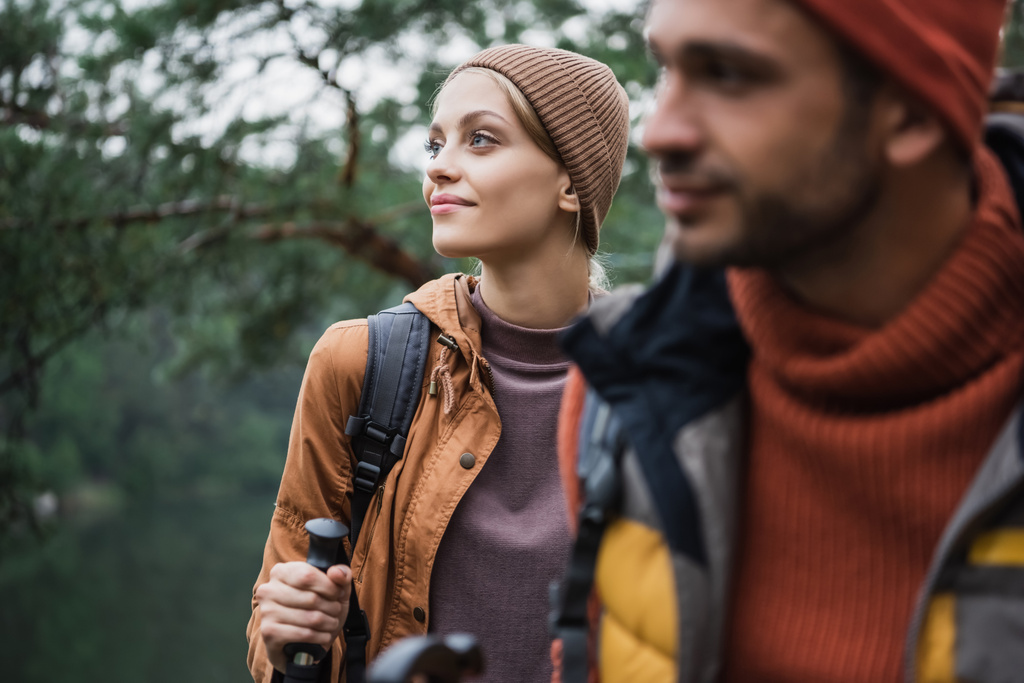 幸せな女性保持ハイキング棒近くボーイフレンド上のぼやけた前景 - 写真・画像