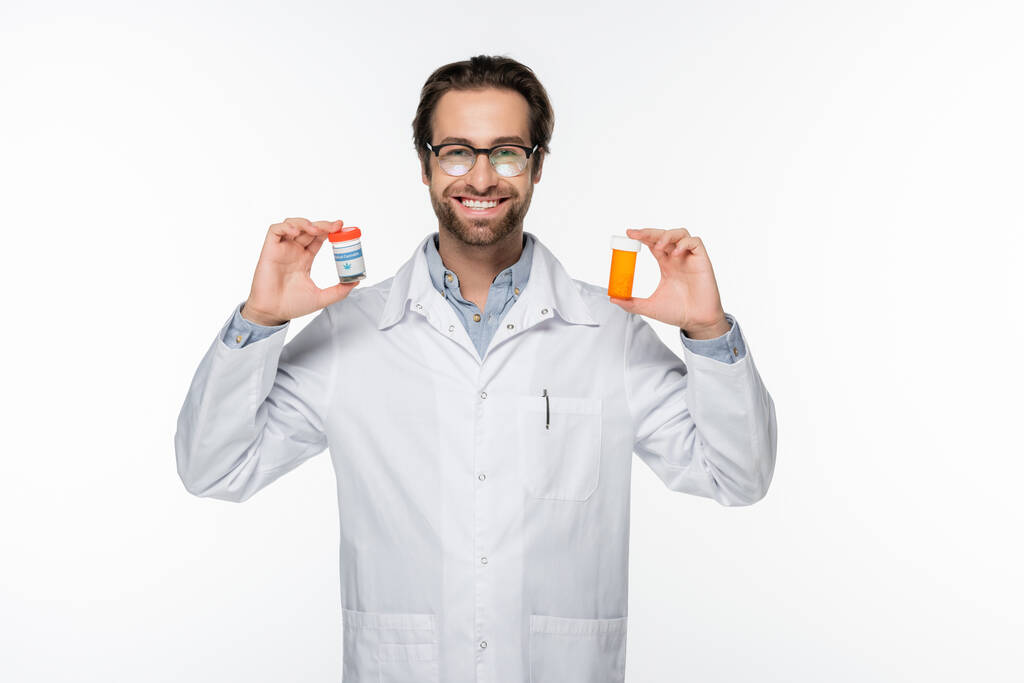 médico sorrindo mostrando recipientes com cannabis medicinal isolado em branco - Foto, Imagem