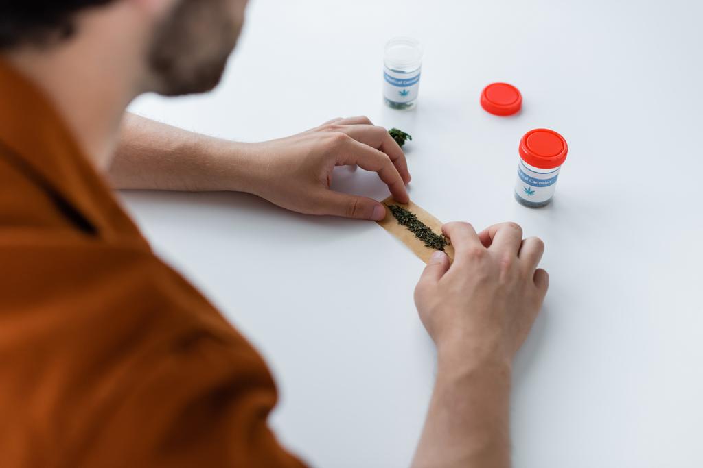 bijgesneden beeld van zieke man maken joint met medische hennep thuis - Foto, afbeelding