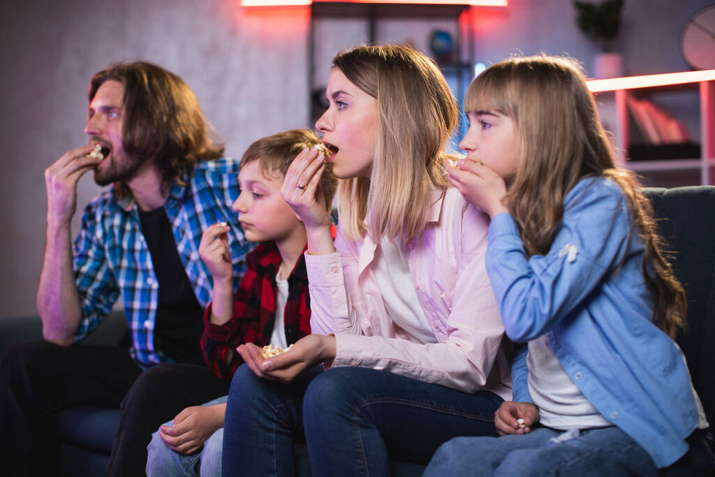 Ouders met kinderen kijken spannende film op TV - Foto, afbeelding